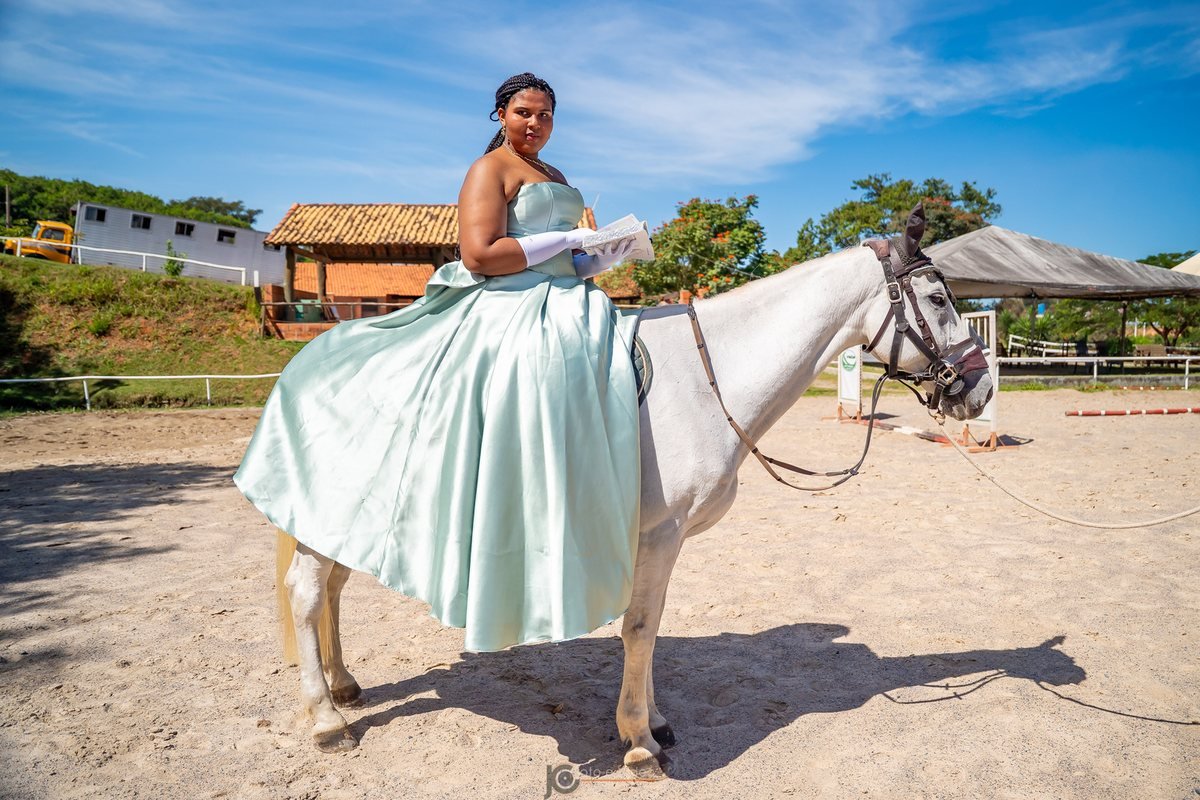 Ester Zion com vestido verde claro ao lado do cavalo branco