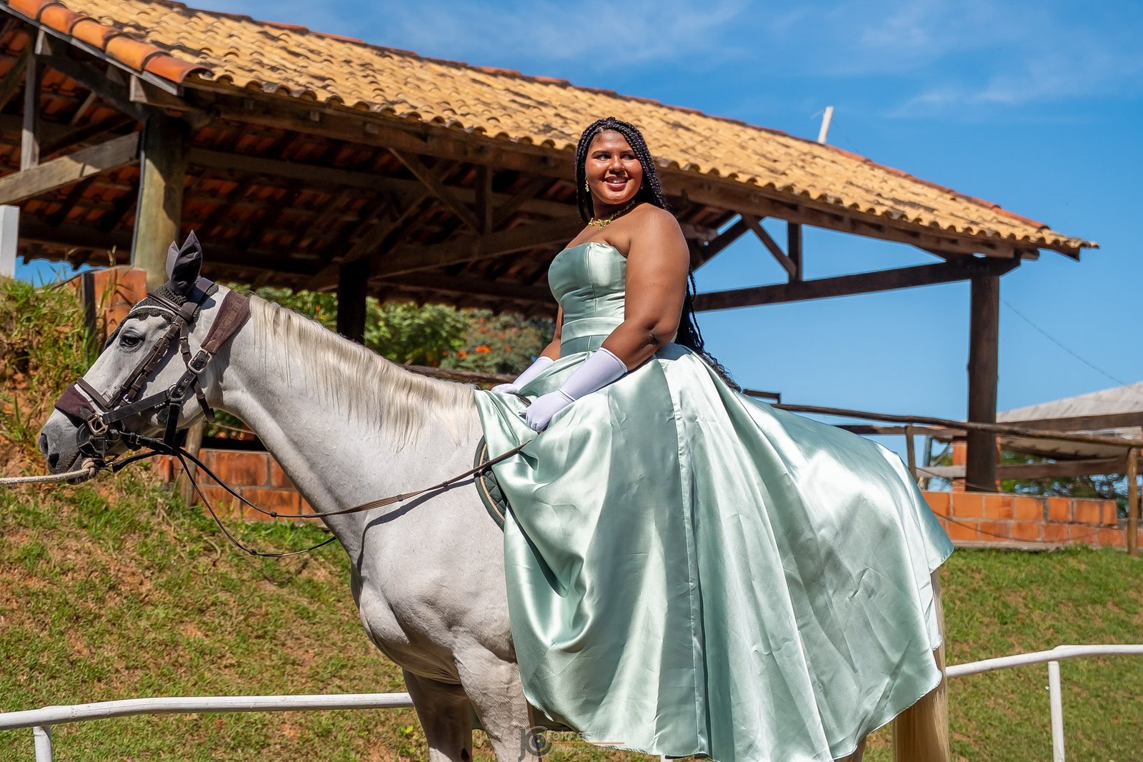 Ester Zion com vestido verde claro montada em um cavalo branco