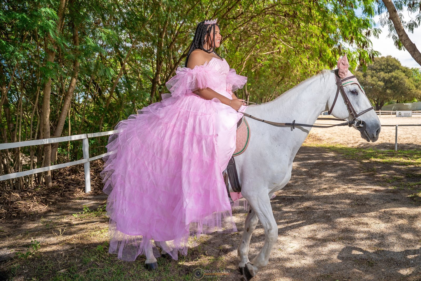 Ester Zion com vestido rosa ao lado de um cavalo branco